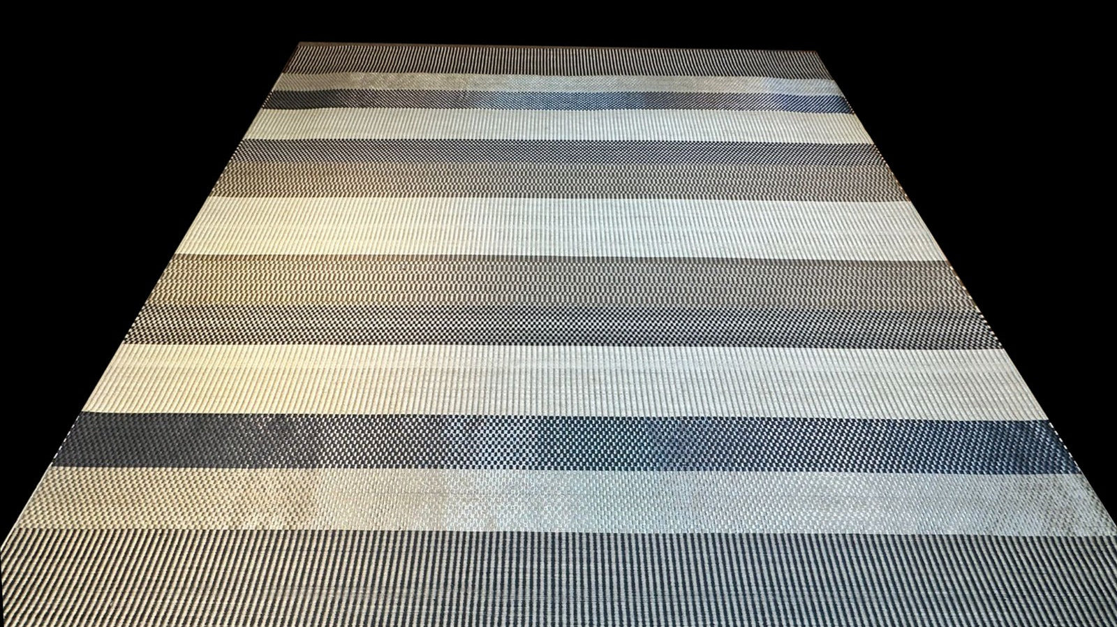 Katünaa handwoven rug with fine metallic copper and natural fiber — close-up of woven texture showing matte fiber and soft bronze thread reflection