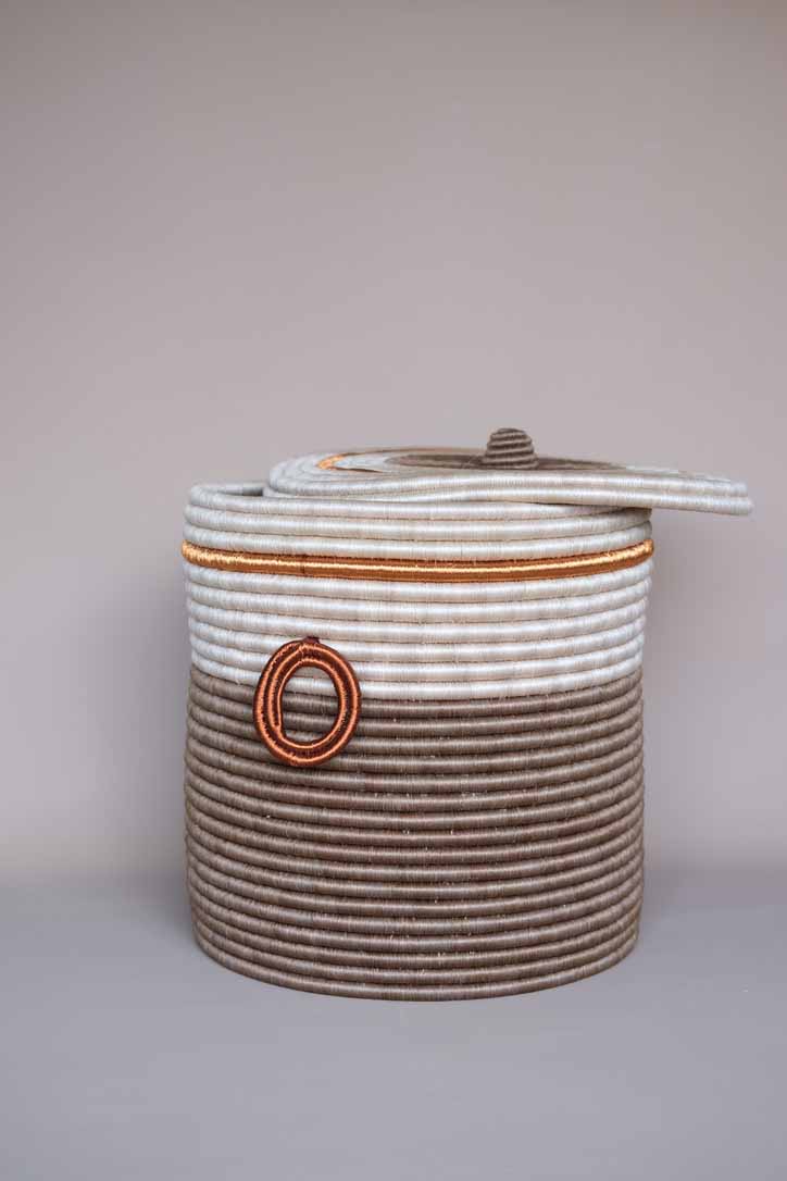 Handwoven brown fique basket with copper detailing, showcasing natural fiber texture and artisanal Colombian craftsmanship.