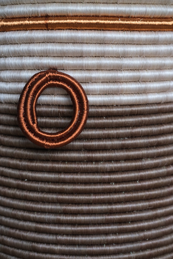 Handwoven brown fique basket with copper detailing, showcasing natural fiber texture and artisanal Colombian craftsmanship.